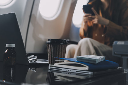 A young Asian woman, seated as an airplane passenger, contemplates dollar bills, reflecting on lucrative opportunities and aspirations towards billionaire status.の写真素材