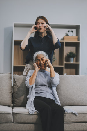 Adult daughter old mom hugging sit on couch enjoy pleasant positive talk, remembering funny occasion from life spend weekend together, caring about older generation relatives express attention conceptの写真素材