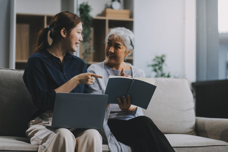 Asian elderly women and friend using social media and living room. Video streaming, happiness and conversation at a house with old people togetherの写真素材
