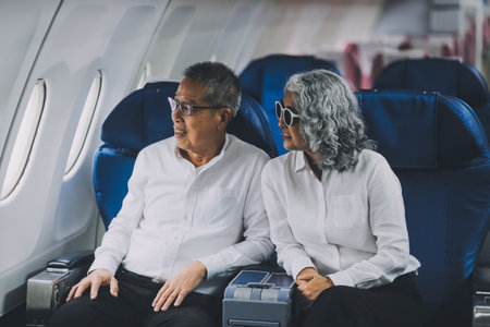 Happy elderly senior couple of travelers with suitcase in airportの写真素材