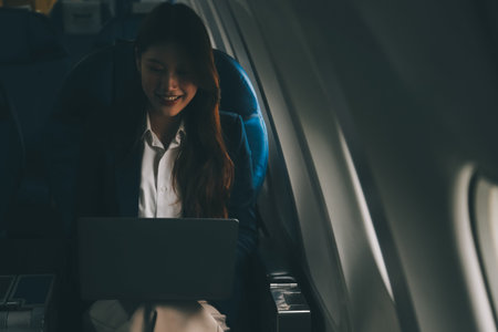Beautiful Asian businesswoman working with laptop in aeroplane. working, travel, business concept
