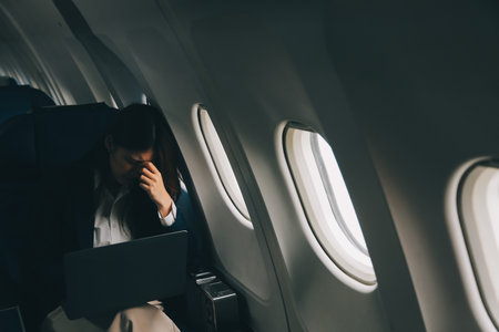Beautiful Asian businesswoman working with laptop in aeroplane. working, travel, business conceptの写真素材