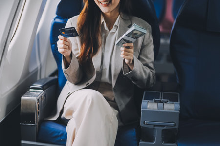 Young businesswoman holding credit card near blurred devices in private planeの写真素材