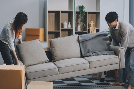 Asian Female discussing new project with male colleague. Young woman talking with young Asian man with financial on sofa in home officeの写真素材