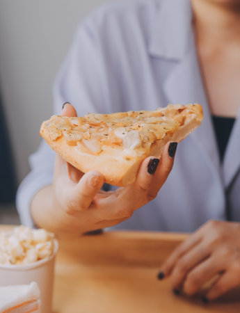 Cropped image of woman holding pizza slice at restaurantの写真素材