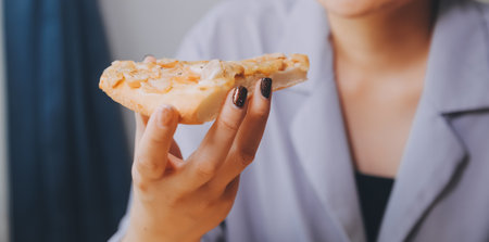 Cropped image of woman holding pizza slice at restaurantの写真素材
