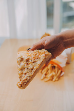 Cropped image of woman holding pizza slice at restaurantの写真素材