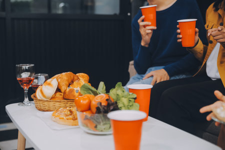 Happy friends making a toast with beer before eating pizza in a shared apartment.の写真素材