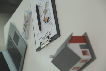 Real estate agent home sales broker is using a pen pointing to the house model and explains the...
