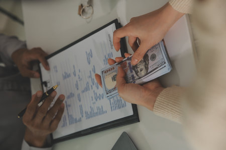 Real estate agent home sales broker is using a pen pointing to the house model and explains the...