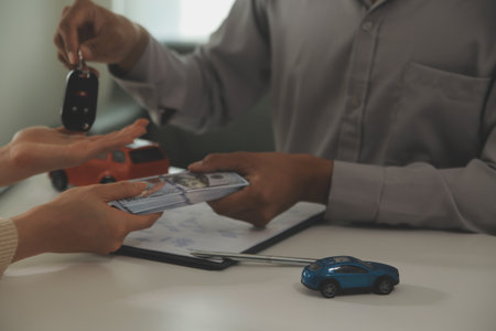 Young man receives a key from car salesman. After agreeing to a contract for rent or sale of a car...