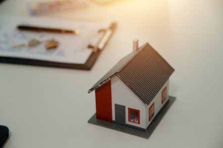 Real estate agent home sales broker is using a pen pointing to the house model and explains the business contract, rent, buy, mortgage, loan, or home insuranceの写真素材