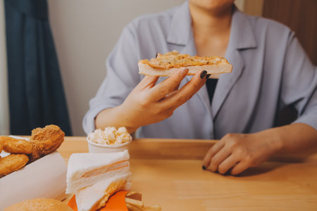 Cropped image of woman holding pizza slice at restaurantの写真素材