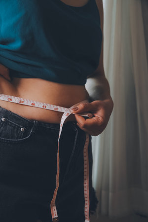 fat woman, fat belly, chubby, obese woman hand holding excessive belly fat with measure tape, woman...