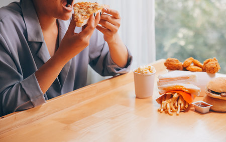 Cropped image of woman holding pizza slice at restaurantの写真素材