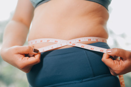 fat woman, fat belly, chubby, obese woman hand holding excessive belly fat with measure tape, woman...