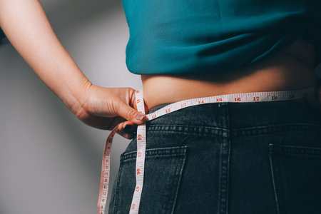 fat woman, fat belly, chubby, obese woman hand holding excessive belly fat with measure tape, woman...