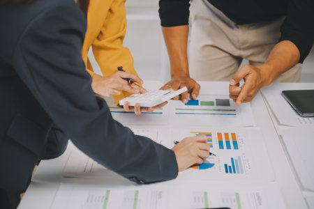 Financial analysts analyze business financial reports on a digital tablet planning investment project during a discussion at a meeting of corporate showing the results of their successful teamwork.の写真素材