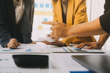 Financial analysts analyze business financial reports on a digital tablet planning investment project during a discussion at a meeting of corporate showing the results of their successful teamwork.の写真素材