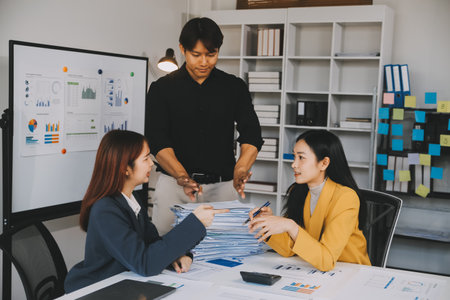 Financial analysts analyze business financial reports on a digital tablet planning investment project during a discussion at a meeting of corporate showing the results of their successful teamwork.の写真素材