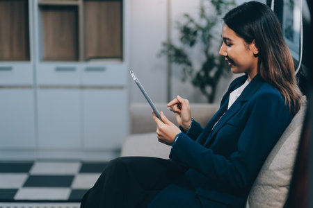 Business woman working from home. work online on laptop. Asian businesswoman working on sofa online business with social distancing laptop online meetingの写真素材