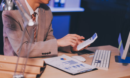 Business accounting concept Businessman uses calculator with laptop computer Budget and borrowed paper Calculate expenses, expenses, taxes online, manage company budgets, close-up imagesの写真素材