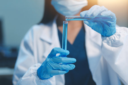 Group of dedicated scientist conduct chemical experiment in medical laboratory, carefully drop precise amount of liquid from pipette into test tube for vaccine drug or antibiotic development. Neotericの写真素材