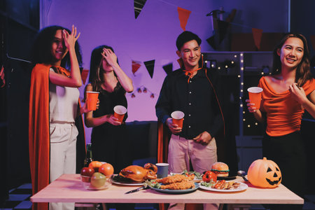 Joyful office Halloween party with coworkers in costumes, celebrating with drinks and laughter, fostering teamwork and festive spiritの写真素材