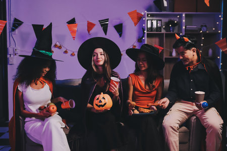 Joyful office Halloween party with coworkers in costumes, celebrating with drinks and laughter, fostering teamwork and festive spiritの写真素材