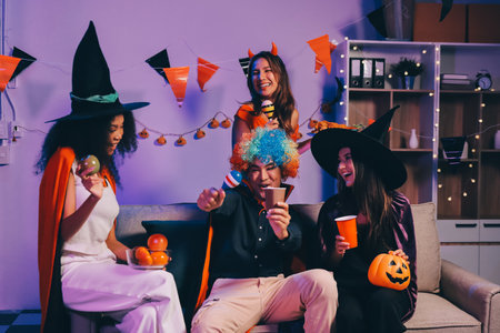 Joyful office Halloween party with coworkers in costumes, celebrating with drinks and laughter, fostering teamwork and festive spiritの写真素材