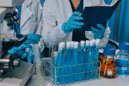 Scientist using microscope in laboratory. Close-up of a researcher's hands adjusting a modern microscope in a lab setting. Science conceptの写真素材