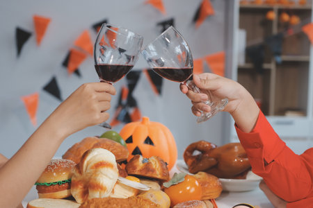 friendship, holiday and people concept - group of happy smiling friends in halloween costumes of vampire, devil, witch and cheetah at home partyの写真素材