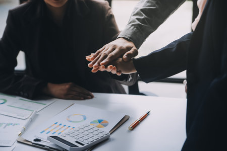 Handshake in agreement against young business people in board room meeting