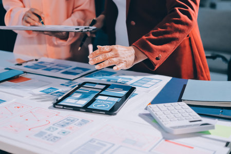 Young Asian business creative team work together, mobile application software design project....
