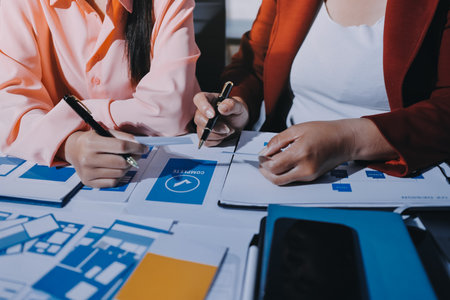 Young Asian business creative team work together, mobile application software design project. Brainstorm meeting, internet technology, smartphone web app designer, office coworker teamwork conceptの写真素材