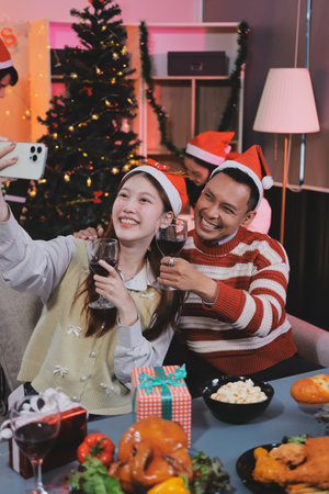 Group of happy Asian friends celebrating Christmas and decorate the Christmas tree indoors. Beauty...