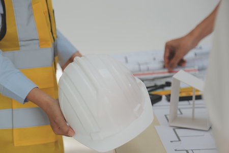 Construction and structure concept of Engineer or architect meeting for project working with partner and engineering tools on model building and blueprint in working site, contract for both companies.の写真素材