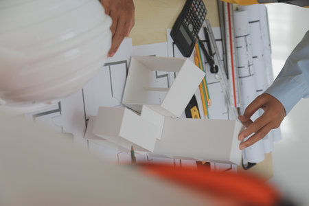 Construction and structure concept of Engineer or architect meeting for project working with partner and engineering tools on model building and blueprint in working site, contract for both companies.の写真素材