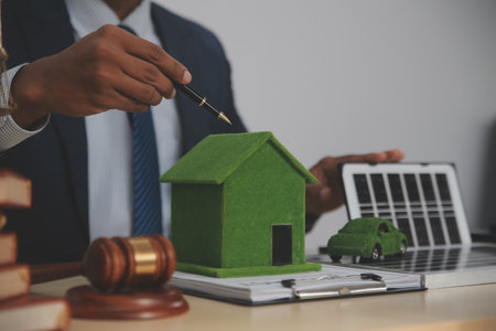 Auctioneer knocks down property sale by sample house and lawyer's gavel, judge mediates in property dispute in court car judge's gavel on wooden background Buying and selling real estate, housingの写真素材