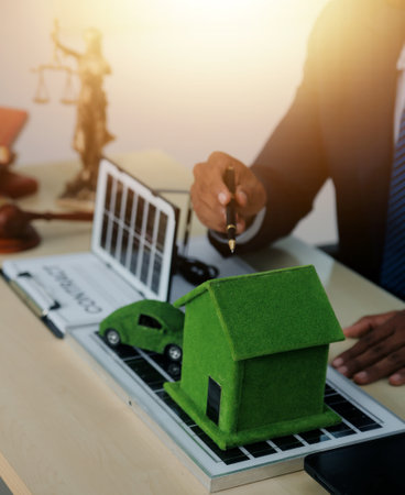 Auctioneer knocks down property sale by sample house and lawyer's gavel, judge mediates in property dispute in court car judge's gavel on wooden background Buying and selling real estate, housingの写真素材