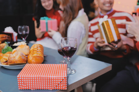 Friends opening Christmas gifts in living roomの写真素材