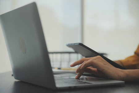 Close up Business woman using calculator and laptop for do math finance on wooden desk, tax, accounting, statistics and analytical research conceptの写真素材