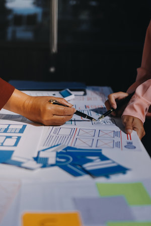 Young Asian business creative team work together, mobile application software design project....