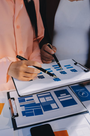 Young Asian business creative team work together, mobile application software design project. Brainstorm meeting, internet technology, smartphone web app designer, office coworker teamwork conceptの写真素材