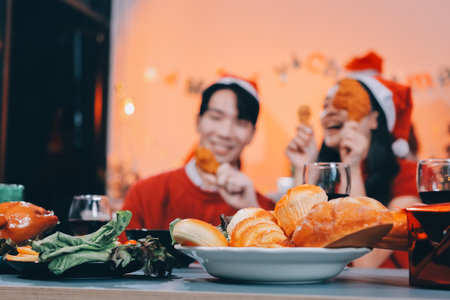 Group of young Asian man and women as friends having fun at a New Year's celebration, holding gift boxes standing by Christmas tree decoration, midnight countdown Party at home with holiday season.の写真素材