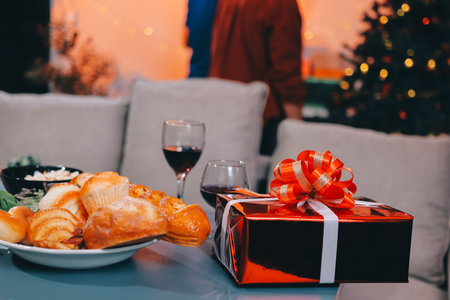 Group of young Asian man and women as friends having fun at a New Year's celebration, holding gift boxes standing by Christmas tree decoration, midnight countdown Party at home with holiday season.の写真素材