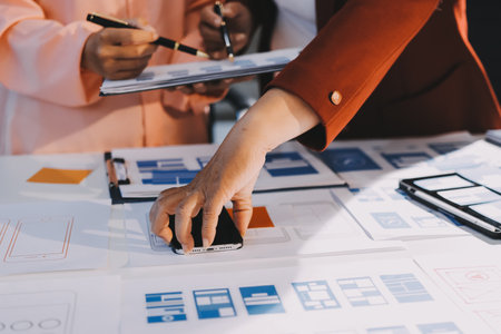 Young Asian business creative team work together, mobile application software design project. Brainstorm meeting, internet technology, smartphone web app designer, office coworker teamwork conceptの写真素材