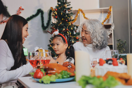 Portrait of Asian family exchanging presents during christmas at home. Attractive happy people...