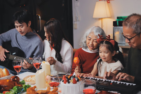 Multi-Generation Family Celebrate Christmas At Home Wearing Santa Hats And Antlers Opening Presentsの写真素材