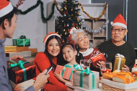 Happy family with gifts celebrating Christmas togetherの写真素材
